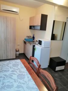 a small kitchen with a white refrigerator and a chair at Femili Hotel Diveda in Sveti Vlas