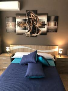a bedroom with a bed with four pictures on the wall at Hostal Doña María in Valdemoro