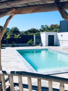 a swimming pool in a backyard with a wooden fence at LA POINTE D’ASPRETTO in Ajaccio