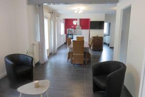 a living room with chairs and a table and a kitchen at Le gîte du Coche avec vue sur la Marne in Damery