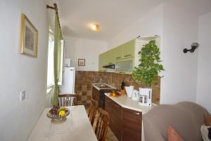a kitchen with a table and a counter top at Apartment Neda in Rabac