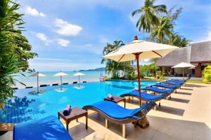 een zwembad in het resort met blauwe stoelen en parasols bij Sea Valley Resort in Lipa Noi