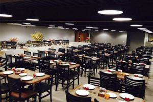 a large dining room with tables and chairs at Palmier Hotel & Convenções in Itaboraí