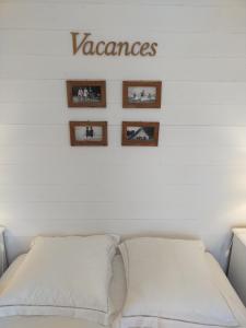 a bedroom with a white bed and pictures on the wall at Chambre d'hôtes Larosa in Moulis-en-Médoc