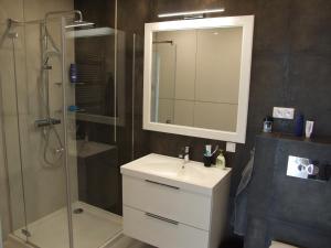 a bathroom with a sink and a shower with a mirror at Apartament nad morzem, Gdańsk Zaspa in Gdańsk +11 photos
