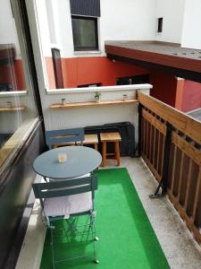 a small table and chairs on a balcony with a green floor at Le Galibier in La Salle Les Alpes