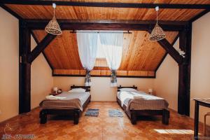2 łóżka w pokoju z drewnianym sufitem w obiekcie Detskaya Konnaya Akademiya Ruteniya w mieście Wsiewołożsk