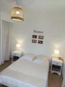 a bedroom with a white bed and two tables at Chambre d'hôtes Larosa in Moulis-en-Médoc