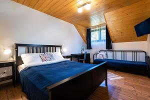ein Schlafzimmer mit einem großen Bett mit einer blauen Decke in der Unterkunft Ubytovanie&Reštaurácia Bodliak in Žiar