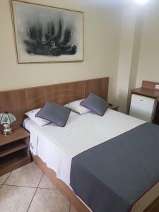 Un dormitorio con una gran cama blanca con almohadas azules. en San Francisco Plazza Hotel, en São Paulo 46 fotos más