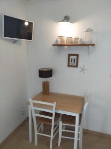 a dining room table with two chairs and a tv at Chambre d'hôtes Larosa in Moulis-en-Médoc