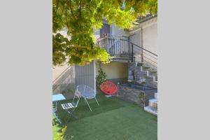 a patio with a red table and chairs and a staircase at Appartement st Victor in Puyvert
