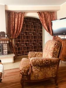 salon z krzesłem i telewizorem w obiekcie Villa Kniazia w Białowieży