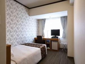 a hotel room with a bed and a television at Hotel Hiroshima Garden Palace in Hiroshima