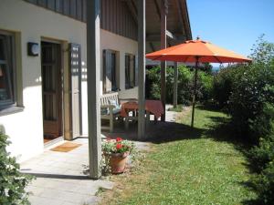 a patio with an umbrella and a table and a bench at Ferienhaus Nienaber in Grafenau