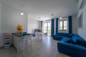 - un salon avec un canapé bleu et une table dans l'établissement La Luna nel Golfo - Appartamenti a Follonica, à Follonica