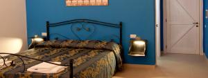 a bedroom with a bed with a blue wall at Le Pentume in Arnesano