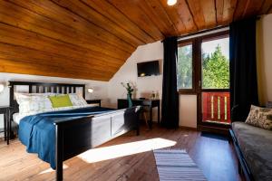 ein Schlafzimmer mit einem Bett und einer Holzdecke in der Unterkunft Ubytovanie&Reštaurácia Bodliak in Žiar
