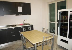 uma cozinha com uma mesa e cadeiras e um frigorífico em B&B Paradiso em Falerna