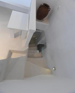 a white staircase with a vase on top of it at The stone in Tinos