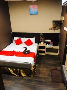 a bedroom with a large bed with red pillows at Highway Times Inn Hotel in Ipoh