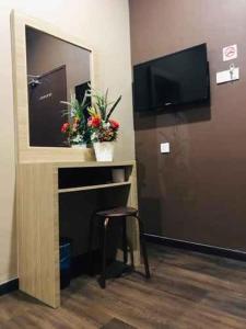 a room with a flat screen tv and a stool at Highway Times Inn Hotel in Ipoh