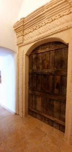 una grande porta in legno in una stanza con un muro di Due forni affittacamere a Matera