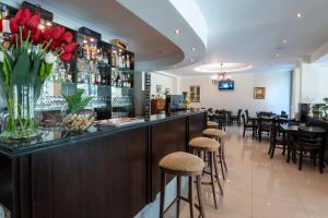a bar in a restaurant with red flowers on the counter at Sveti Dimitar Hotel in Primorsko