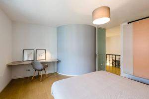 a bedroom with a bed and a desk and a chair at Lago Welcome Clausen I in Luxembourg