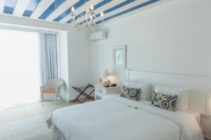 a bedroom with a white bed and a blue ceiling at Villa Raphael in Búzios