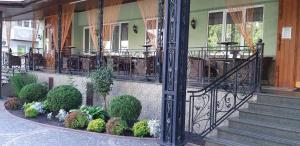 a porch of a building with a bunch of plants at Ідилія in Zhensna Polʼska