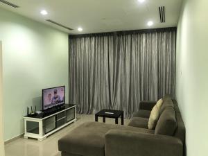 a living room with a couch and a flat screen tv at KLCC Apartment in Kuala Lumpur