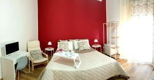 a bedroom with a bed and a red wall at B&B Civico 20 in Palermo