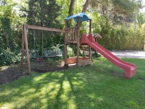 a playground with a slide in the grass at Complejo La Veguilla in Arroyo del Ojanco