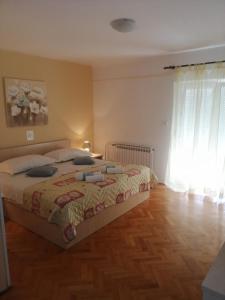 a bedroom with a bed and a wooden floor at Apartments Jasna in Rab