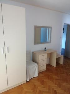a white room with a desk and a mirror at Apartments Jasna in Rab