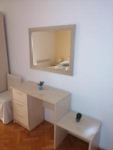 a room with a desk and a mirror on the wall at Apartments Jasna in Rab