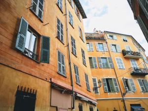 een hoog gebouw met veel ramen aan een straat bij Ze Perfect Place - Spacieux appartement - Cours Saleya - 2 CHB - 2 SDB - AC in Nice