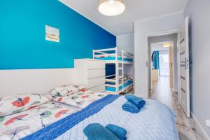 1 dormitorio con paredes azules y 1 cama con sábanas azules en Apartamenty Olivia, en Władysławowo