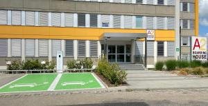 un edificio con una cancha de baloncesto verde delante de él en A2 Boarding House Memmingen en Memmingen