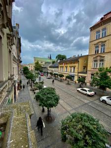 a person walking down a city street with buildings at Ametyst Apartments in Krakow