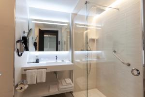 a white bathroom with a sink and a shower at Hotel Liabeny in Madrid