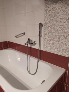 a bath tub with a shower in a bathroom at Aegean View Apartment in Kavála