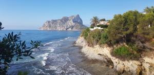 a view of a beach with a house on a cliff at Villa Elvira apartamento in Calpe