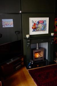 sala de estar con chimenea y TV en Bedlam House en Newquay