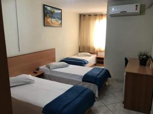 una habitación de hotel con dos camas y un escritorio en San Francisco Plazza Hotel, en São Paulo