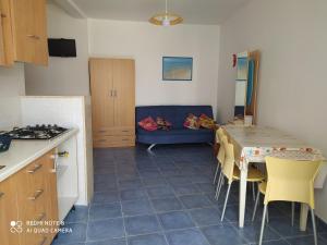 a kitchen and a living room with a table and a couch at SAMARCANDA camere e appartamenti in Porto Cesareo