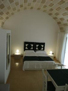a bedroom with a bed and a table with two lamps at B&B Corte San Giuseppe in Casarano +55 photos
