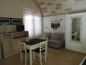 a kitchen and living room with a table and chairs at B&B Corte San Giuseppe in Casarano