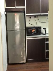 a kitchen with a stainless steel refrigerator and a microwave at Homestay Fekrifarisha SA in Shah Alam